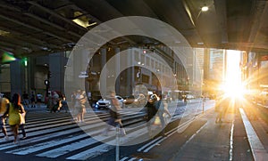 Sunlight shining on people walking across a busy street crosswalk at Grand Central Station in Manhattan New York City photo