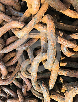 Sunlight shining on the rusted links of an old anchor chain.