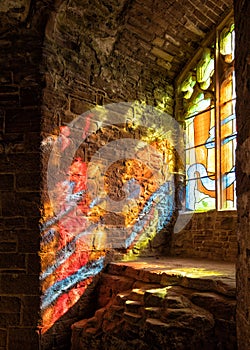 Sunlight streaming through a stained glass window, Goodrich Castle, Herefordshire.