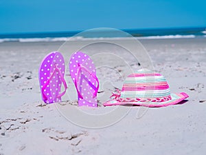 Sunlight Summer composition. Beach flip flops on tropical ocean sand. against blue sea and sky background. Beach Accessories