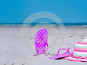 Sunlight Summer composition. Beach flip flops on tropical ocean sand. against blue sea and sky background. Beach Accessories