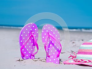 Sunlight Summer composition. Beach flip flops on tropical ocean sand. against blue sea and sky background. Beach Accessories