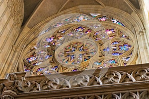 Sunlights through colorful stained glass in patterned window in Vitus Cathedral in Prague
