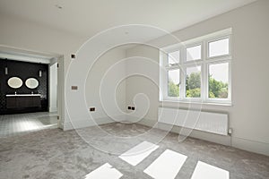 Sunlit bedroom with doors open to ensuite bathroom