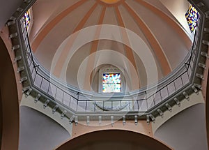 Sunlit church dome with balcony and stained glass windows