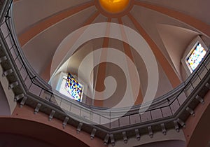 Sunlit church dome with balcony and stained glass windows