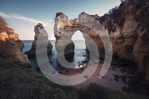 Sunlit Coastal Landscape: Majestic Rock Formation Arching Over a Pebbled Beach, ai generative