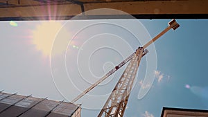 Sunlit Construction Crane Over Urban Development Site Under a Clear Sky