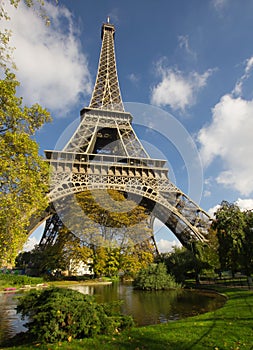 Sunlit Eiffel Tower, Paris, over park and lake