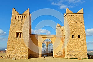 Sunlit facade of an old fort with tracery doors