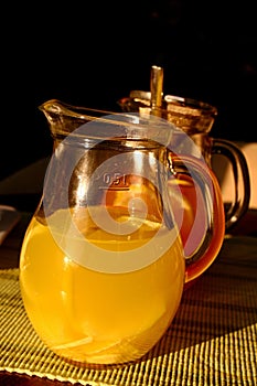 Sunlit glass jars with fresh grapefruit and orange juice.