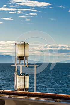 Sunlit glass and metal sternlight of ship. Stephen`s Passage, Alaska, USA.