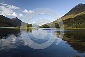 Sunlit island against mountain reflection