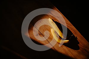 A sunlit kitchen moment: banana placed on the table. Dark shadow