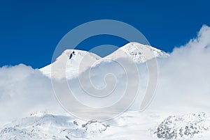 Sunlit Mount Elbrus in clouds.