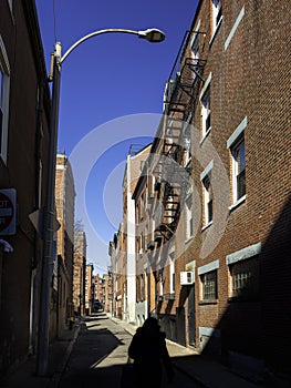 Sunlit narrow alley of red brick buildings in East Boston, Massachusetts