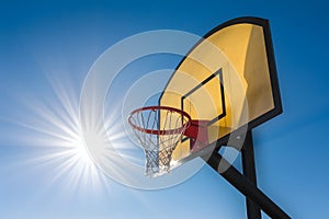 Sunlit outdoor basketball hoop exudes sportsmanship and energy