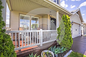 Sunlit porch with chairs against wood and stone brick wall and window of a home