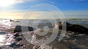 Sunlit Rocky Seashore - Waves Gently Washing Over Stones