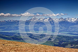 Sunlit snowy Tatra peaks and green forests in spring Slovakia