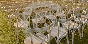 Sunlit white chairs on a bright green lawn