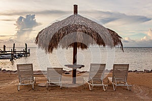 Sunlounge chairs and umbrella on the sunset beach in Florida Keys