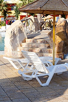 Sunloungers on swimming pool