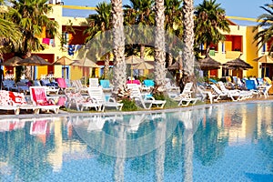 Sunloungers on swimming pool