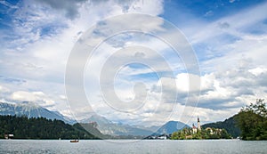 Sunning panoramic view of The island of Bled, Bled castle on cliff, Julian Alps and Church of the Assumption,Bled, Slovenia.