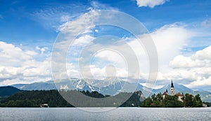 Sunning panoramic view of The island of Bled, Bled castle on cliff, Julian Alps and Church of the Assumption,Bled, Slovenia.