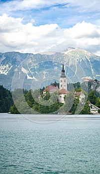 Sunning panoramic view of The island of Bled, Bled castle on cliff, Julian Alps and Church of the Assumption,Bled, Slovenia.