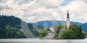 Sunning panoramic view of The island of Bled, Bled castle on cliff, Julian Alps and Church of the Assumption,Bled, Slovenia.