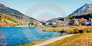Sunny autumn view of Resia village and lake. Amazing morning panorama of Italian Alps, South Tyrol, Italy, Europe. Traveling