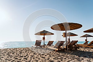 Sunny beach day with straw umbrellas and lounging chairs