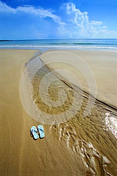 Slunný pláž překlopení flopy na písek 
