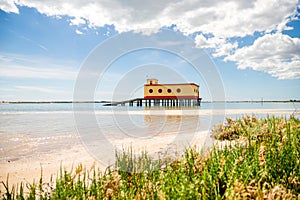 Sunny beach view of the historical life-guard building in Fuseta, Ria Formosa Natural park, Portugal