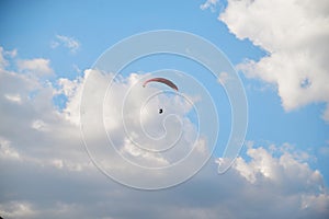 Sunny bright blue sky background with white clouds in summer. Paragliding extreme sport in the rural mountain area. Lonely