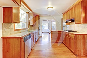 Sunny brown kitchen interior with hardwood floor and white ceiling