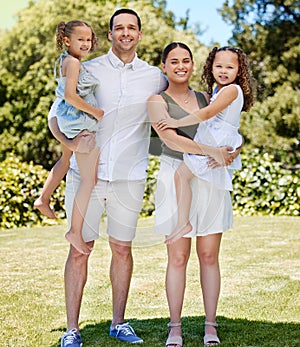 A sunny day brings out the biggest smiles. Portrait of a happy young family enjoying a fun day out at the park.