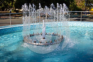 Sunny day, Fountain in the Children`s Park.Several jets spurted up.Drops, splashes, ripples on the water