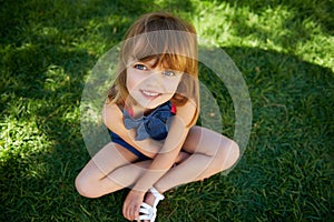 Sunny day fun. Shot of a cute little girl smiling while lying down on grass.