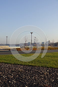 Sunny day with green grass and blue sky. Young trees. Reidi tee promenade. Modern space for walking and rest in a city