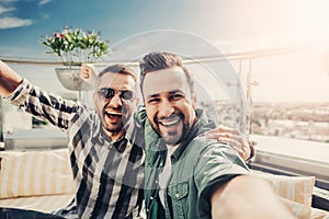 Cheerful friends at outdoor cafe making selfie