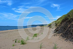 Sunny day at Inverness Beach on Cape Breton Island, Nova Scotia, a popular beach with wide sand dunes and surrounded by high hills