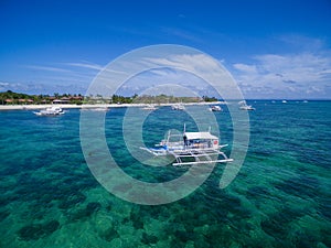 Sunny Day in Malapascua Island in Visayan Sea, One of Cebu Island. Sea water and Boats. Bounty Beach with Local Architecture