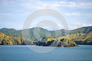 Sunny day with Nature background. Small island in New Zealand. Hills and mountains in summer.