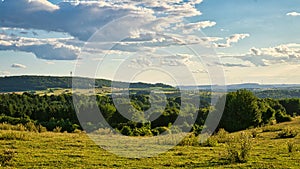 A sunny day in the Saarland with a view over meadows into the valley