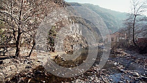 Sunny day view over rocky river with flowing water panorama wide mountain forest