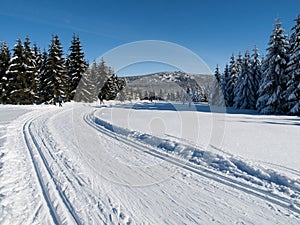 Sunny day on winter mountains with groomed cross-country trails