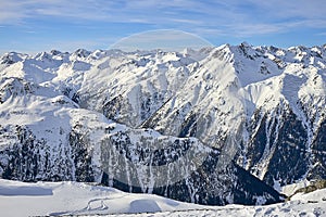 Sunny December day in Silvretta Alps - winter view on snow covered mountain slopes and blue sky Austria.